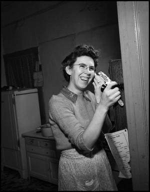 Primary view of object titled '[Woman laughing on the phone in the kitchen, 2]'.