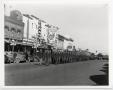 Photograph: [World War II soldiers march past Theatre Row on the Denton square]