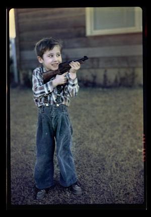 Primary view of object titled '[Young Byrd Williams IV holding a gun]'.