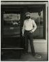 Photograph: [Photograph of man in front of a piano restoration building]