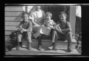 Primary view of object titled '[Irene Williams sitting on a porch with her sons]'.