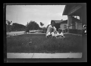 Primary view of object titled '[Irene Williams sitting in her front yard with her sons John and Byrd III]'.