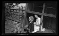 Photograph: [Irene sitting in a chicken coop with Charles Williams]