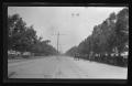 Photograph: [A street lined with horse drawn carriages and a trolley lines]