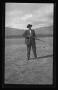 Photograph: [Byrd Williams, Jr. holding a gun in the desert]
