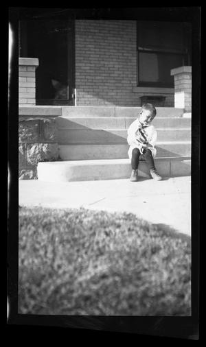 Primary view of object titled '[Photo of Byrd III sitting on steps in front of a house]'.