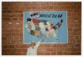 Photograph: [Worker Pointing At The Names Project National Tour 88 Quilt Map]