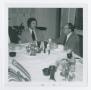 Photograph: [Two Men Conversing at Table]