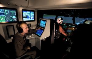 Primary view of object titled '[Three pilots in a flight simulator pod]'.