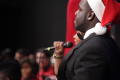 Photograph: [Man in Santa Hat Singing on Stage]