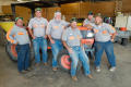 Photograph: [UNT facilities and maintenance workers pose with tractor]