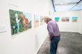 Photograph: [Cowboy Examining Photograph at Exhibit]