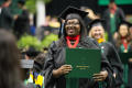 Thumbnail image of item number 1 in: '[Graduate student holds diploma]'.