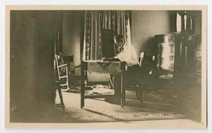 Primary view of object titled '[Photo of Byrd Williams Jr. at a table, from the Byrd Williams Jr. album, 1907-1920]'.