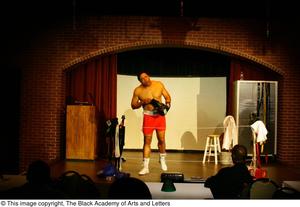 Primary view of object titled '[Vincent Cook Putting on Boxing Gloves on Stage]'.