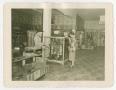 Photograph: [Photograph of Myres and a woman inside his shop]