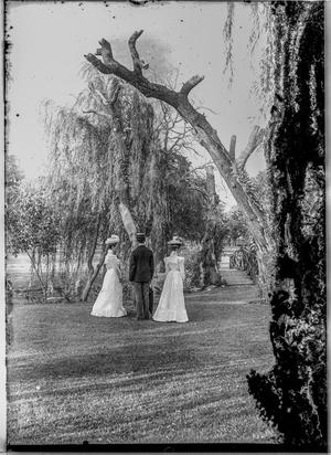Primary view of object titled '[Two Women and One Man Stand in Park]'.