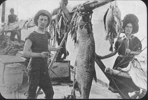 [Man and women posing with a giant fish]