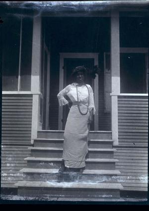 [Photograph of a Woman on the Steps of a House]