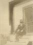Primary view of [Man Sitting on the Steps of a House]