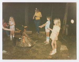 Primary view of object titled '[Children Cooking Hot Dogs Over a Campfire]'.