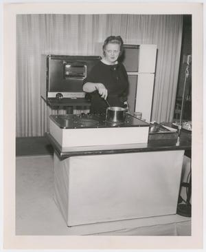 [Photograph of Helen Corbitt cooking]