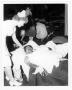Photograph: [A nurse in a makeshift hospital comforts a victim of the 1947 Texas …