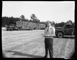Primary view of object titled '[J. F. McAdams in Front of Semi Trucks]'.