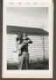 Photograph: [Man Holding Child in Front of Home]