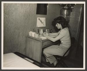 [Woman Sitting at a Desk]