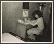 Photograph: [Woman Sitting at a Desk]