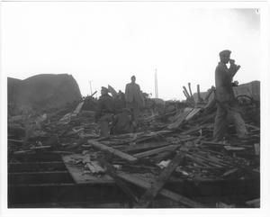 [Searching the debris near a damaged storage tank after the 1947 Texas City Disaster]