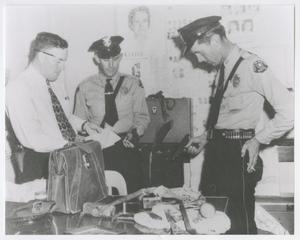 Primary view of object titled '[Abilene Police Officers Examining Burglary Evidence]'.