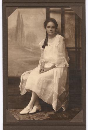 [Young Woman Seated Wearing Light Color Clothing]