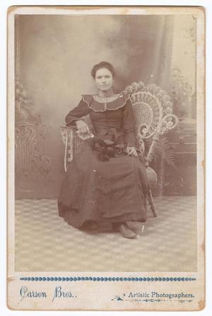 [Unknown Woman Sitting in Wicker Chair Indoors]