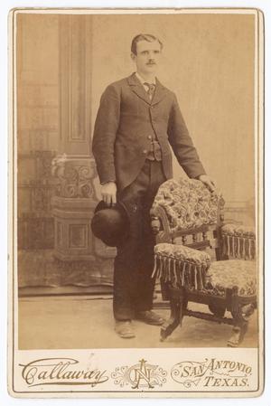 [Unknown Young Man Standing Next to Fabric Chair]