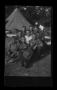 Photograph: [McCann poses with CCC Camp members in front of tent]