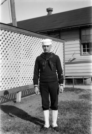 Primary view of object titled '[Sailor Standing Next to a Lattice Fence]'.
