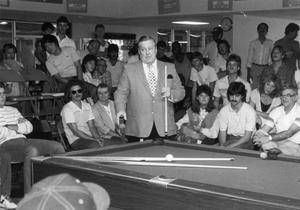[Professional billiards player Jack White explains a trick to students.]