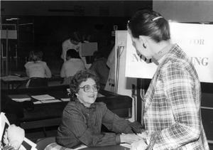 [Barbara Watkins, Financial aid officer, helps a student during registration.]