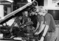 Photograph: Auto mechanics students working with a car engine.