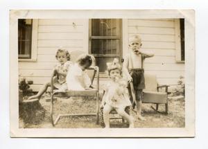 Primary view of object titled '[Barbara Loving, Virginia Loving, Martha Elaine, and Aron Alexander Sitting Outside]'.