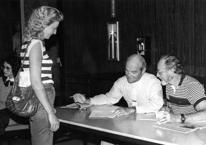 [Mike Hefley and Bruce Roush help a student register for summer physical education courses.]
