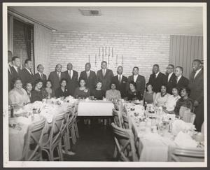 [Men Standing Behind Women at Banquet]