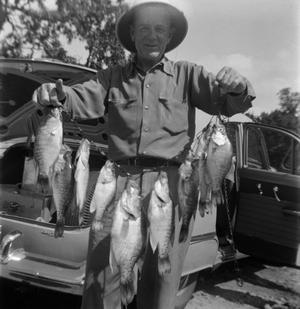 Primary view of object titled '[Man Holding String of Fish]'.