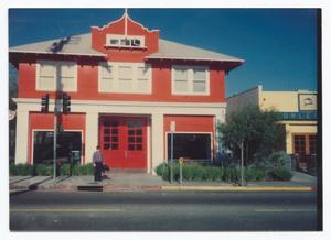 [Man Standing in Front of Red Building]