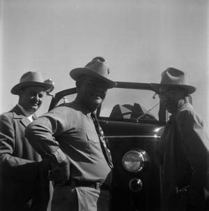 [Three Men in Front of a Vehicle]
