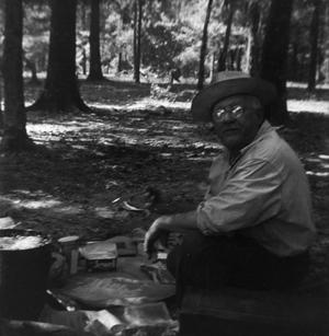 [Man Cooking at Campsite in Woods]