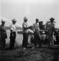 Photograph: [Men Speaking in Front of Lake]
