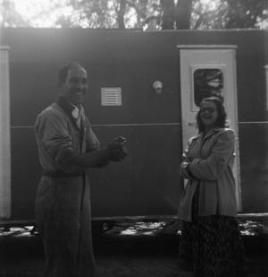 [Man and Woman in Front of Camper]